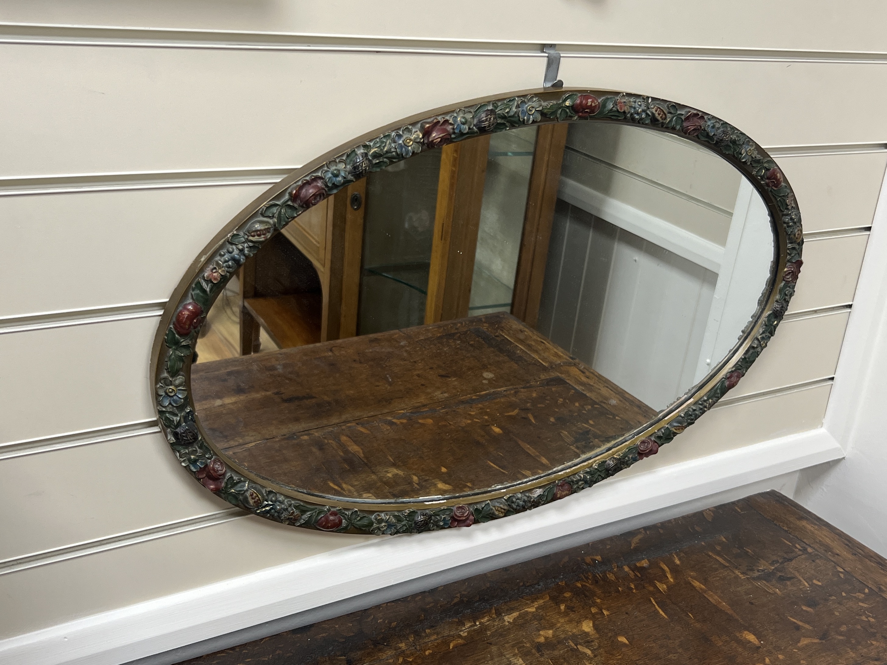 An 18th century style circular wall mirror with vase pediment, width 60cm, height 104cm together with an oval floral moulded wall mirror